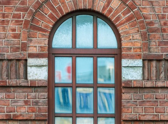 Window with an arch on the background wall of brown brick. From the series window of Saint-Petersburg.